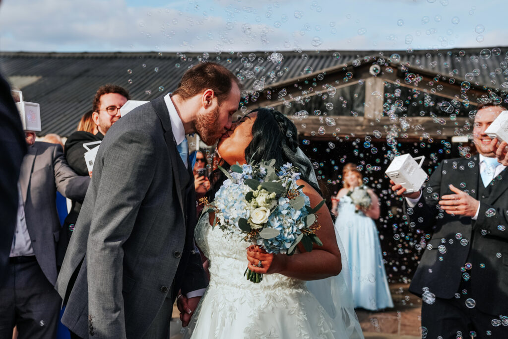 Newlywed couple kissing amid bubbles celebration