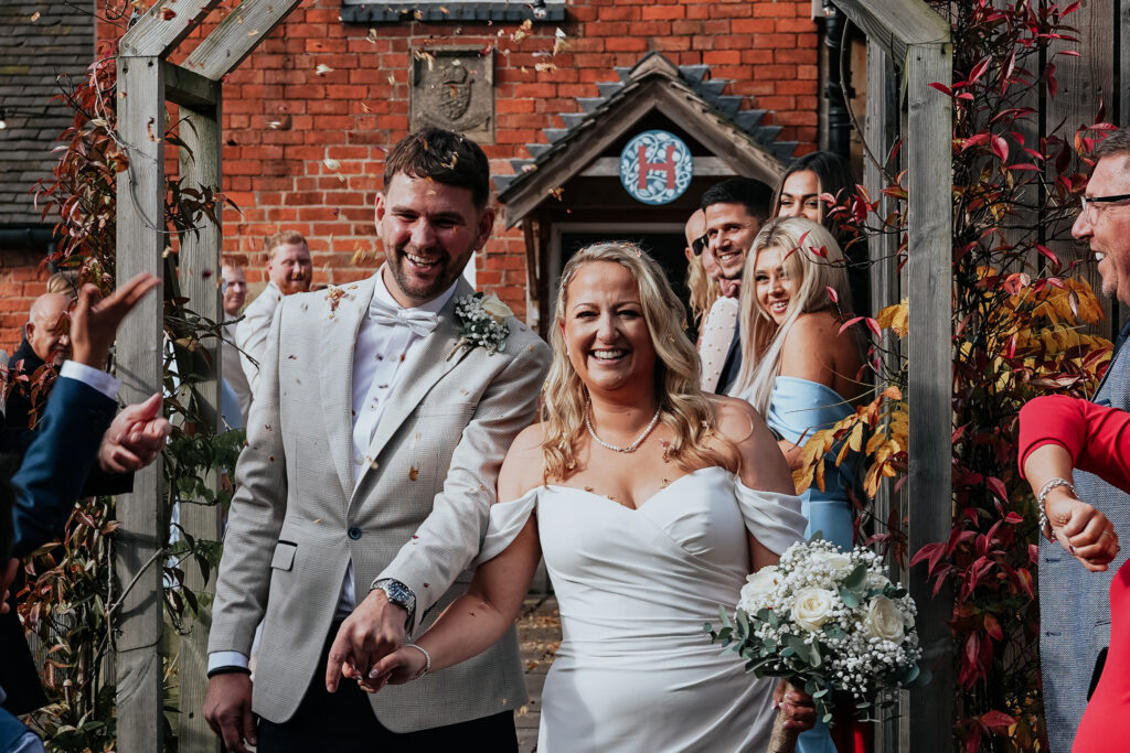 Smiling newlyweds walking after wedding ceremony