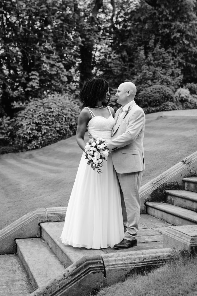 Bride and groom embracing on garden steps